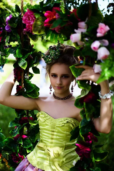 Menina bonita no jardim com flores em vestido de princesa — Fotografia de Stock