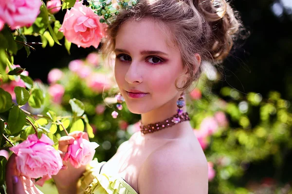 Красива дівчина в саду з квітами в сукні принцеси — стокове фото