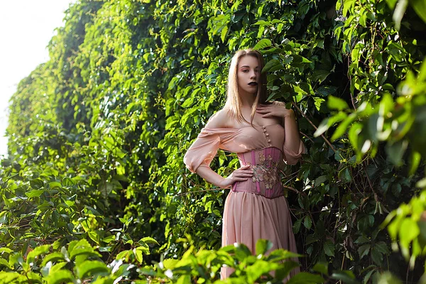 Potret gadis cantik dengan gaun merah muda pastel dan korset dan hiasan bunga — Stok Foto