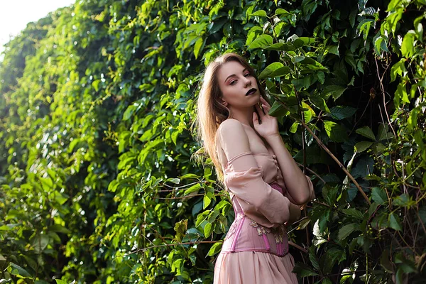 Portrait de belle fille en robe rose pastel et corset et fleur incarnée — Photo