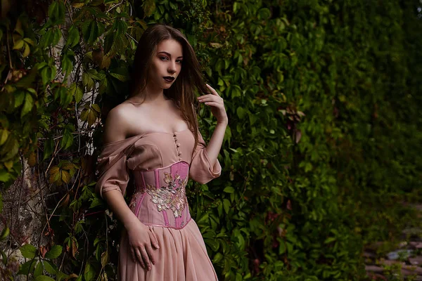 Portrait de belle fille en robe rose pastel et corset et fleur incarnée — Photo