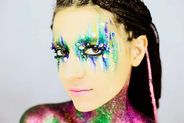 Yakın çekim yaratıcı glitter ile güzel bir kızın portresi makyaj