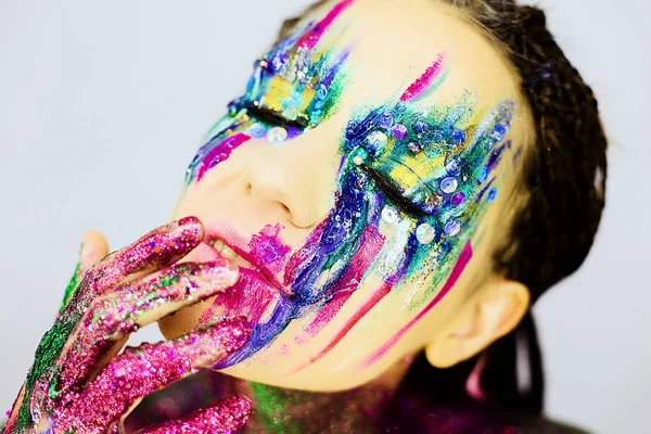 Yakın çekim yaratıcı glitter ile güzel bir kızın portresi makyaj