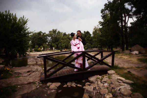 艺伎的女孩嫩粉色和服和高加索人的夫妇的肖像 — 图库照片