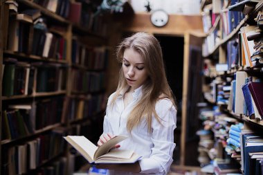 Yaşam tarzı vintage kitaplığındaki veya kitapçı bir güzel öğrenci kız portresi