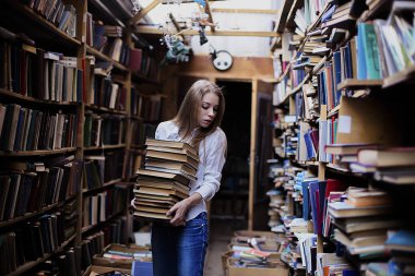 Yaşam tarzı vintage kitaplığındaki veya kitapçı bir güzel öğrenci kız portresi