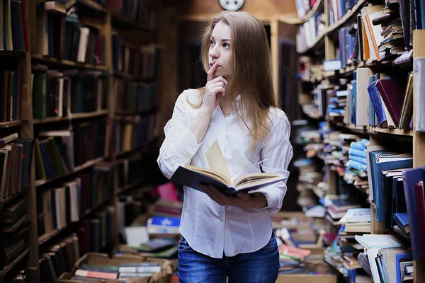 Yaşam tarzı vintage kitaplığındaki veya kitapçı bir güzel öğrenci kız portresi