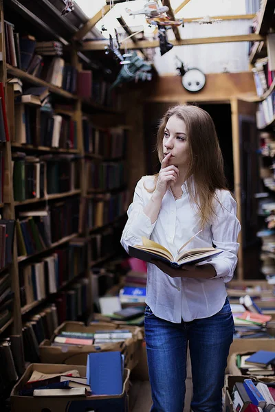 Retrato de estilo de vida de una encantadora estudiante en una biblioteca o librería vintage —  Fotos de Stock