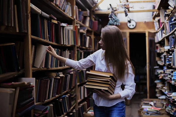 Lifestyle portrait of a lovely student girl in vintage library or bookstore — Stock Photo, Image