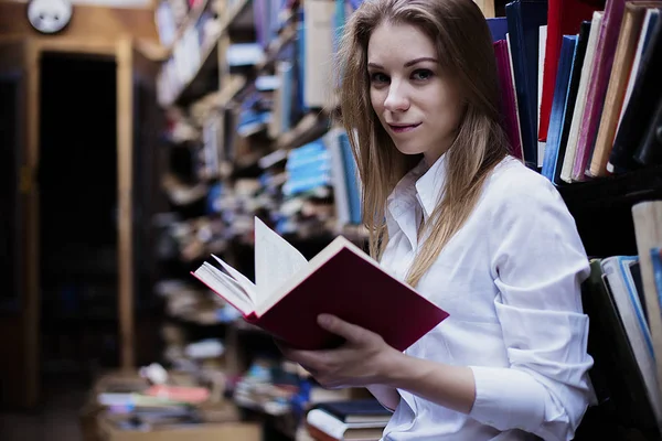 Retrato de estilo de vida de uma linda estudante na biblioteca ou livraria vintage — Fotografia de Stock