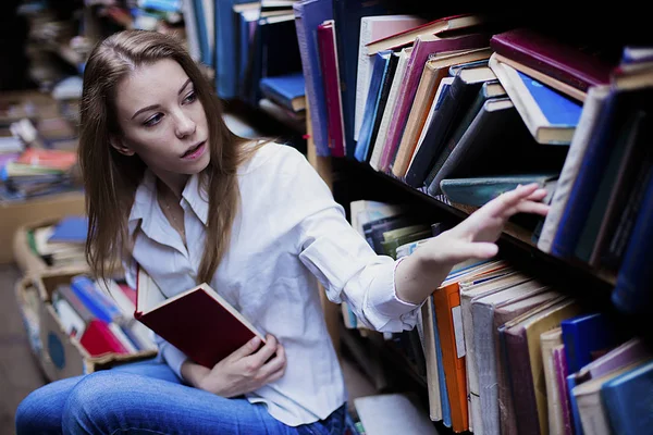 Retrato de estilo de vida de uma linda estudante na biblioteca ou livraria vintage — Fotografia de Stock