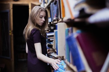 Yaşam tarzı vintage kitaplığındaki veya kitapçı bir güzel öğrenci kız portresi