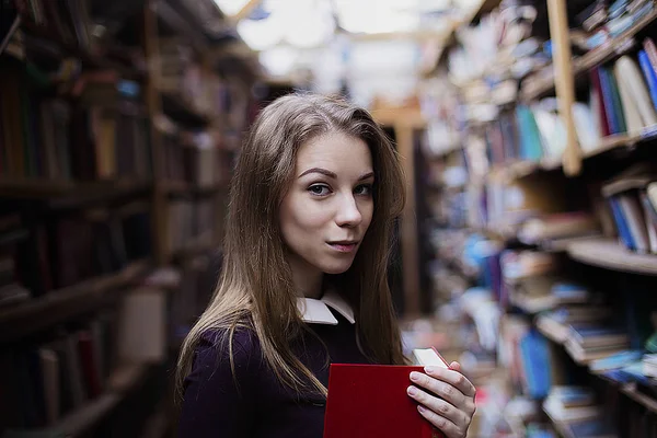 Retrato de estilo de vida de uma linda estudante na biblioteca ou livraria vintage — Fotografia de Stock