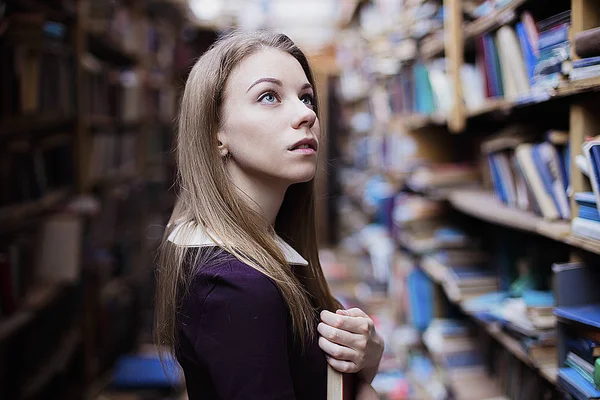 Retrato de estilo de vida de uma linda estudante na biblioteca ou livraria vintage — Fotografia de Stock