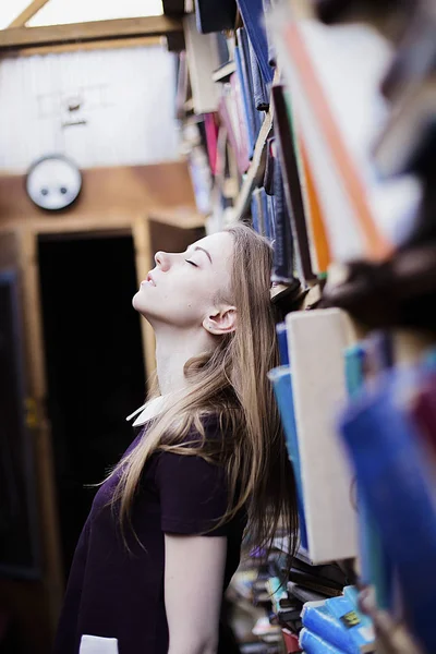 Retrato de estilo de vida de una encantadora estudiante en una biblioteca o librería vintage —  Fotos de Stock