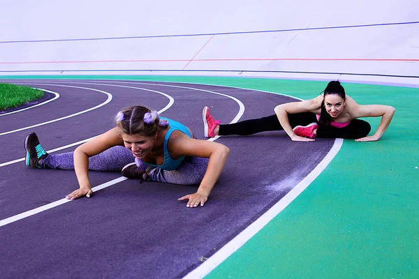 Isınma ve egzersiz yapıyor ve germe iki genç ve atletik kız portresi yaşam tarzı 