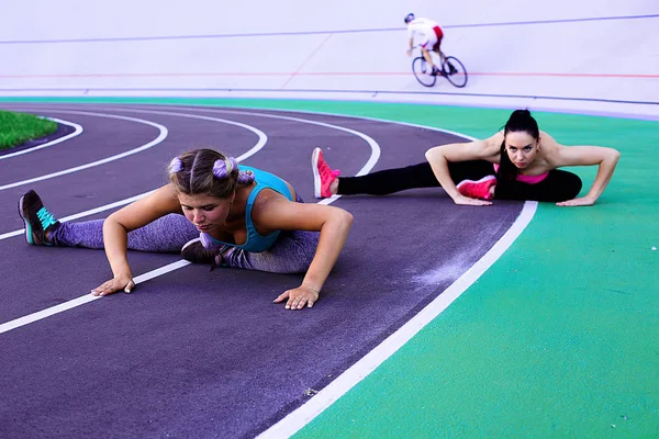 Isınma ve egzersiz yapıyor ve germe iki genç ve atletik kız portresi yaşam tarzı 