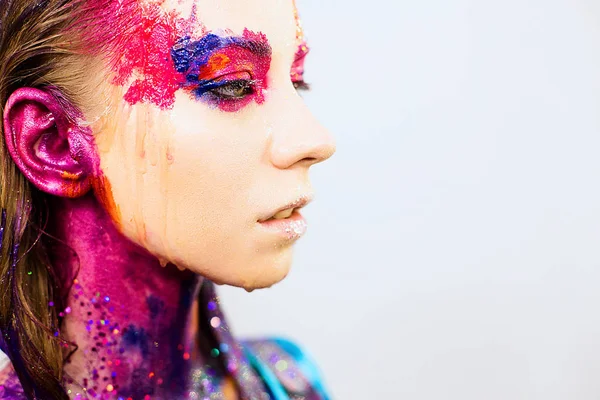 Yakın çekim portre sanat moda yaratıcı glitter makyaj ile genç bir kadın
