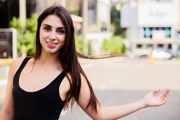 Livsstil porträtt av vackra flicka med smink och lång brunett hår bär svart klänning på gatan. — Stockfoto