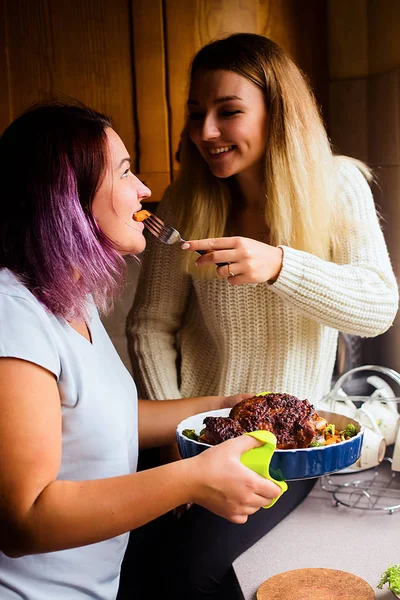 Портрет в стиле жизни двух счастливых молодых женщин с запечённой индейкой на праздничный ужин — стоковое фото