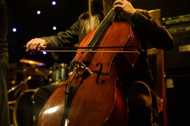 Çello üzerinde Sahne Alanı'nda konser sırasında çalan adam