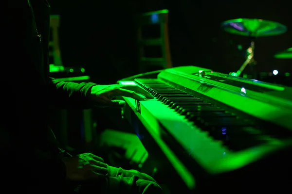 Man playing on synthesizer keyboard on stage during concert — Stock Photo, Image