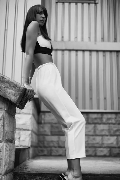 Fashion black and white outdoor portrait of stylish brunette woman on the street