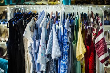 Birkaç güzel elbise bir askıda duruyor. Detaylı bir şekilde, çekimin bazı kısımları kasıtlı olarak maviye boyanmış.