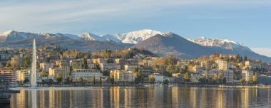 Lugano, İsviçre - 18 Ocak 2018: Göl ve Çeşme Merkez Lugano görünümü. Gün ışığında Apls üzerinde kar.