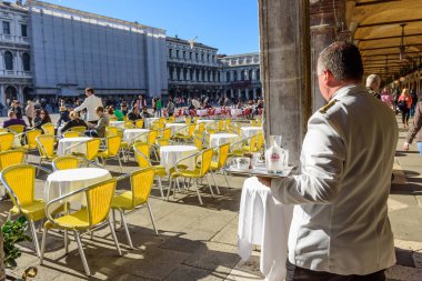 Venice, İtalya - 23 Ekim 2017: Piazza San Marco Vencie İtalya güneşli bir sabah kahve hizmet veren bir garson.