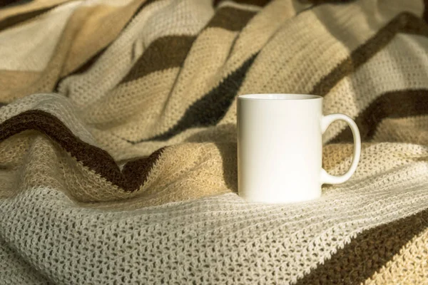 White coffee mug mockup with striped hand woven blanket. Empty mug mock up for design promotion.