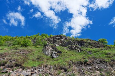 Mavi Gökyüzü bulutlu tepenin üzerinden.