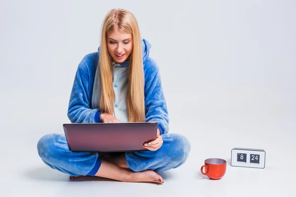 Flicka i pyjamas med en bärbar dator — Stockfoto