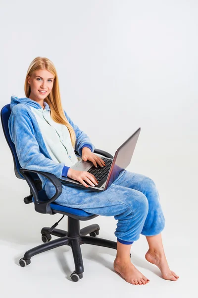 Flicka i pyjamas med en bärbar dator — Stockfoto