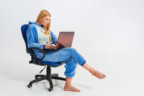 Meisje in pyjama met een laptop — Stockfoto