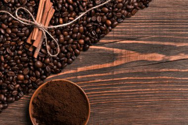 Kahve çekirdekleri, tarçın ve rustik ahşap üzerinde çekilmiş kahve