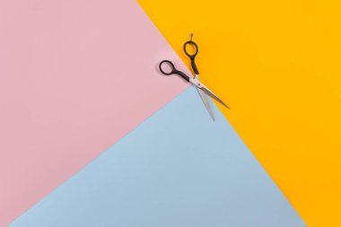 Makas renk pembe, sarı, mavi kağıt arka plan. Üstten Görünüm.