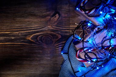 Köknar ağacı dalı Noel ışıkları, hediye kutusu ve şeker ile kopya alanı ile ahşap arka plan üzerinde köpekler.