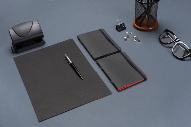 Siyah ofis aksesuarları, gözlük gri arka plan üzerinde bir dizi