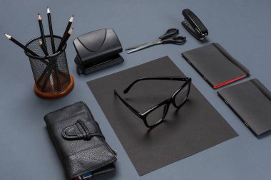 Siyah ofis aksesuarları, gözlük gri arka plan üzerinde bir dizi
