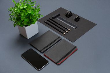 Düz kadar modern sahte dizüstü bilgisayar ve Kırtasiye gri arka plan üzerinde yatıyordu.