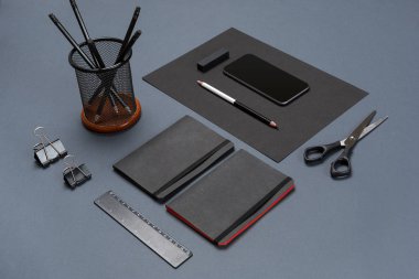 Düz kadar modern sahte dizüstü bilgisayar ve Kırtasiye gri arka plan üzerinde yatıyordu.