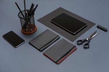 Düz kadar modern sahte dizüstü bilgisayar ve Kırtasiye gri arka plan üzerinde yatıyordu.