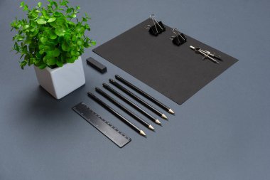 Düz kadar modern sahte boş siyah kağıt levha ve Kırtasiye gri arka plan üzerinde yatıyordu.