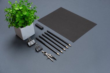 Düz kadar modern sahte boş siyah kağıt levha ve Kırtasiye gri arka plan üzerinde yatıyordu.