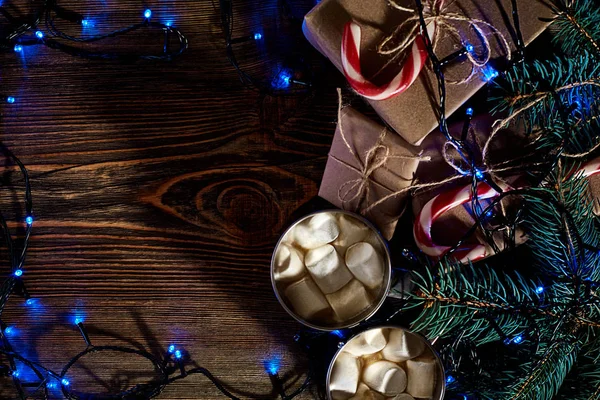 Christmas wooden background with fir tree. Christmas tree branch with decorations on wood background and garland. — Stock Photo, Image