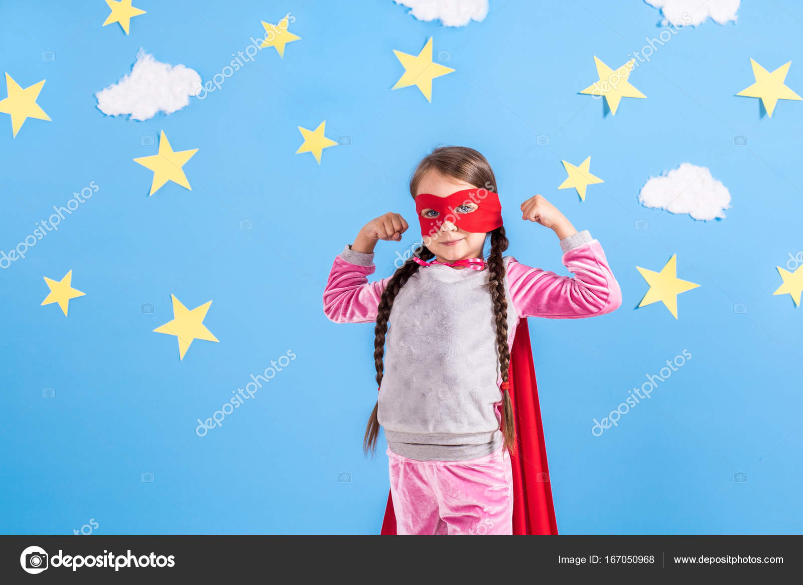 6 年間ブロンドの女の子は楽しんで家にスーパー ヒーローのような格好 明るい水色の壁の背景を子供します ストック写真 C Nazarov Dnepr Gmail Com