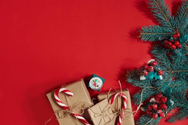 Çam kozalakları, çam dalları ve hediye kutuları kırmızı zemin üzerine yığını Noel bileşimi