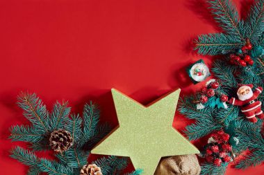 Çam kozalakları, çam dalları ve hediye kutuları kırmızı zemin üzerine yığını Noel bileşimi