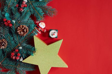 Çam kozalakları, çam dalları ve hediye kutuları kırmızı zemin üzerine yığını Noel bileşimi